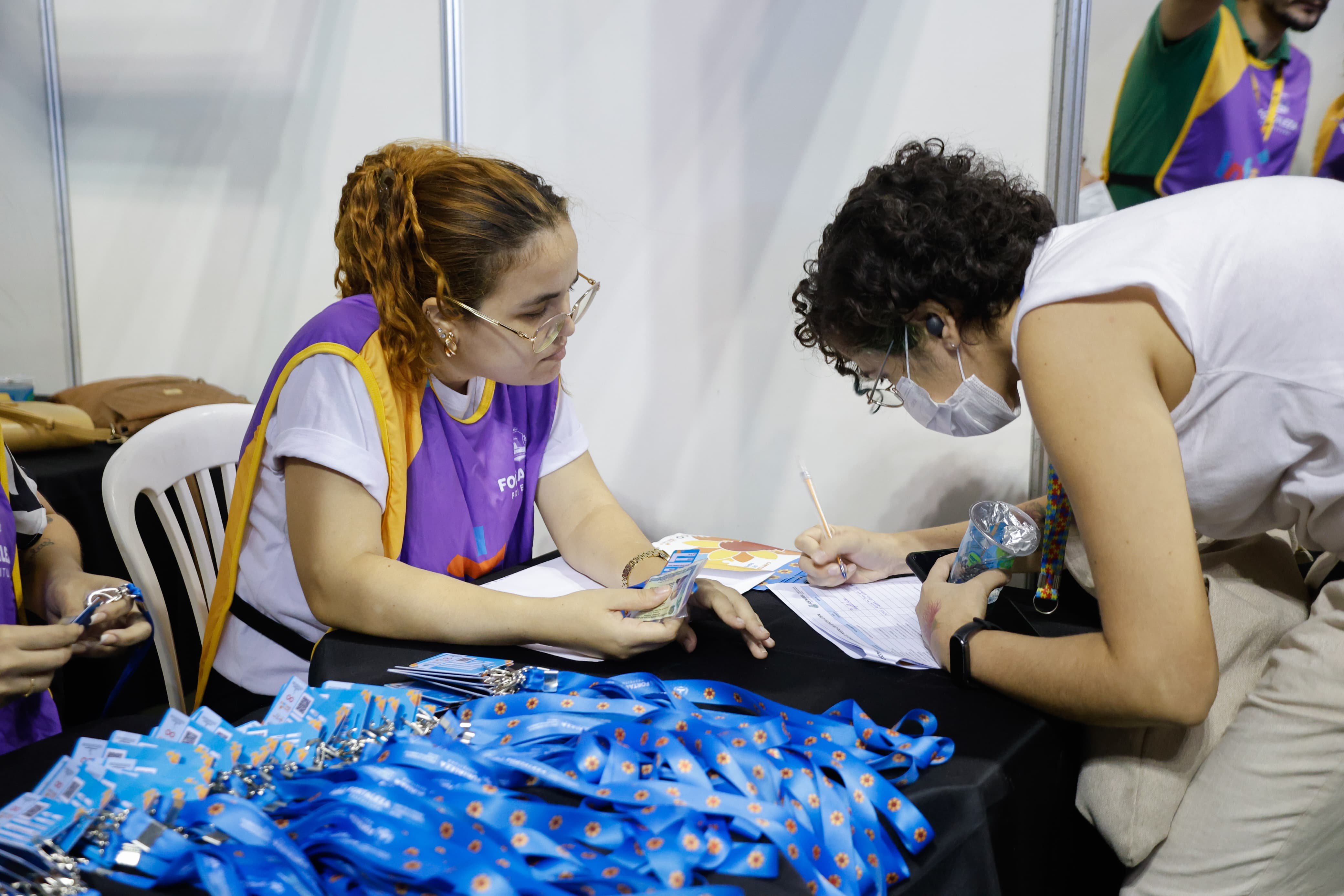 mulher assina documento em uma mesa com os documentos entregues